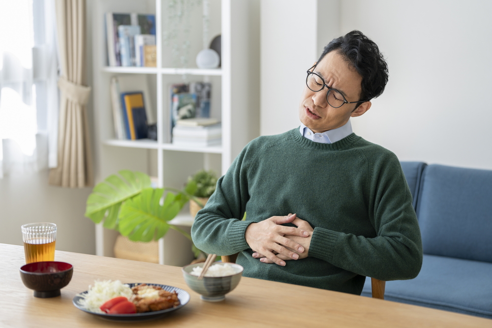 胃もたれをしている男性